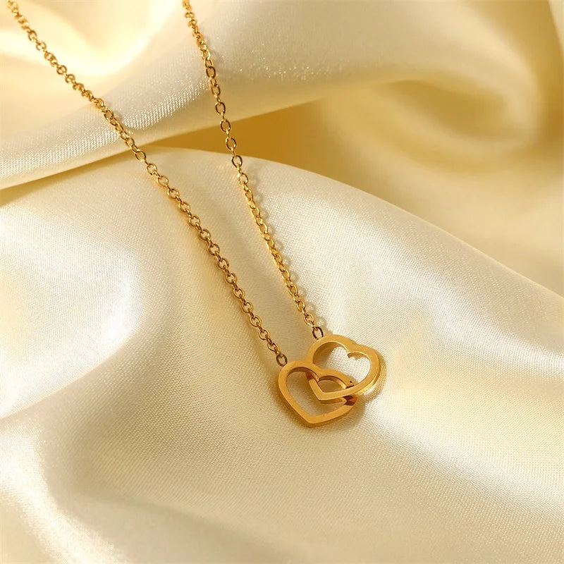 Gouden in elkaar grijpende hartketting | Delicate aanslagvrije liefdeshanger