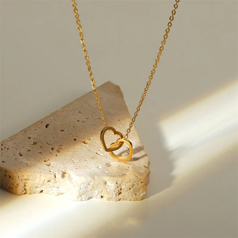 Gouden in elkaar grijpende hartketting | Delicate aanslagvrije liefdeshanger