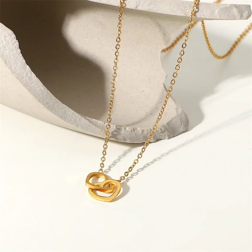 Gouden in elkaar grijpende hartketting | Delicate aanslagvrije liefdeshanger