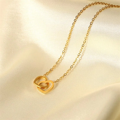Gouden in elkaar grijpende hartketting | Delicate aanslagvrije liefdeshanger