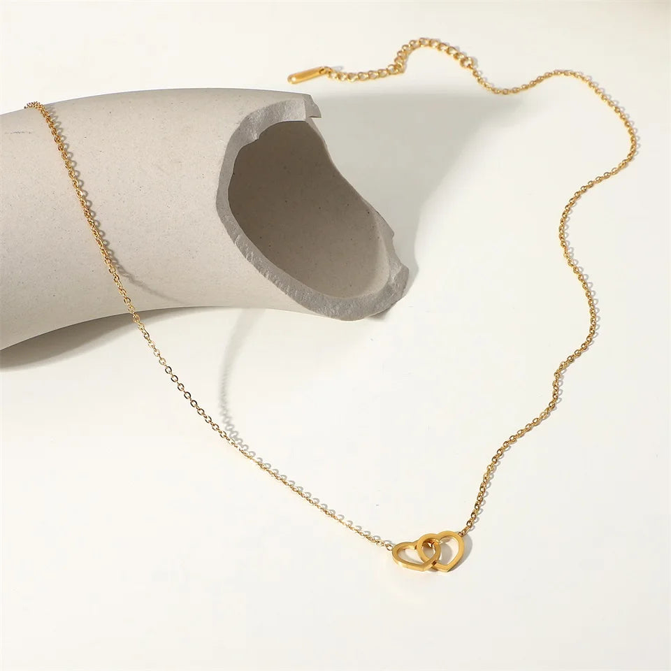 Gouden in elkaar grijpende hartketting | Delicate aanslagvrije liefdeshanger